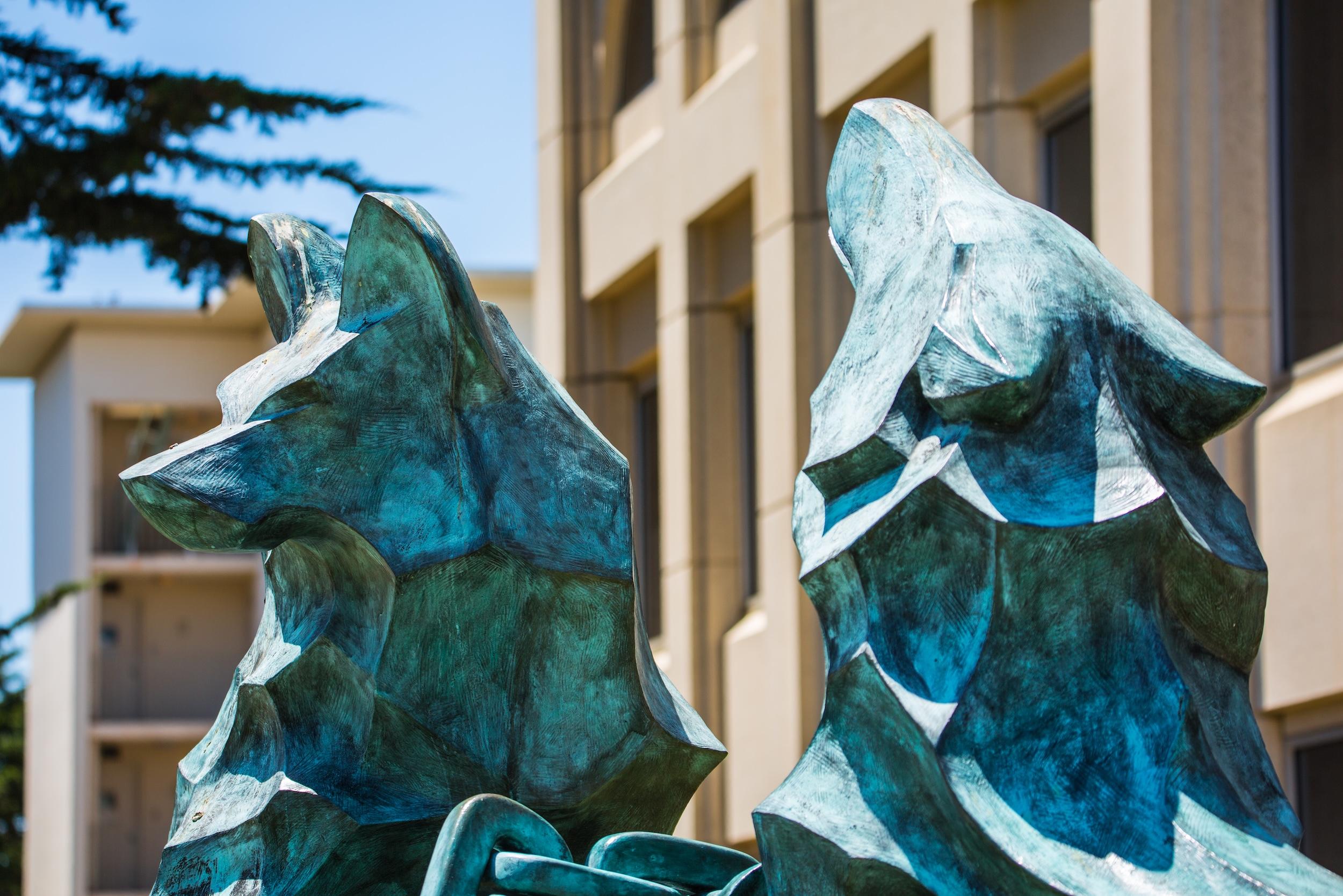 Bronze sculpture of two stylized wolves on the University of San Francisco campus.